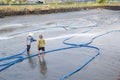 Workers use high pressure water cleaning shrimp pond