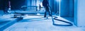 workers use industrial vacuums to clean a concrete floor. The image is dominated by shades of blue, adding to the overall Royalty Free Stock Photo