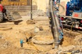 Workers use a suction excavator based on a truck to sample soil in a well for communications