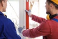 Workers using bubble level for installing window, closeup Royalty Free Stock Photo