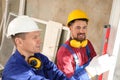Workers using bubble level for installing window Royalty Free Stock Photo