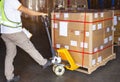 Workers Using Hand Pallet Jack Unloading Packaging Boxes in Storage Warehouse. Delivery Shipment Boxes. Supply Chain. Warehouse Royalty Free Stock Photo