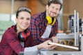 workers using machinery in carpentry workshop