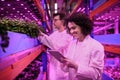 Workers using tablet on aquaponic farm, sustainable business and artificial lighting. Royalty Free Stock Photo