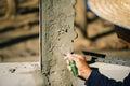 Workers are using a trowel to decorate the cement pillars into a beautiful ridge