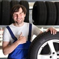 Workers in a warehouse with tyres for changing the car Royalty Free Stock Photo