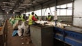 Workers at the waste processing plant. Sorting trash on a conveyor belt