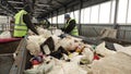 Workers at the waste processing plant. Sorting trash on a conveyor belt