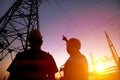 workers watching the power tower and substation with sunset b Royalty Free Stock Photo