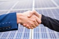Workers in work clothes greet each other by the hand before starting work on solar panels. Royalty Free Stock Photo