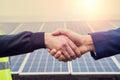 Workers in work clothes greet each other by the hand before starting work on solar panels. Royalty Free Stock Photo
