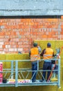 Workers work on a construction site. Work is underway on the laying of panels of wall insulation from red brick. Royalty Free Stock Photo