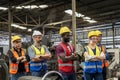 Workers and workers are standing in the factory. Group Staff Standing In Engineering Factory