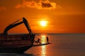 The workers are working to adjust mooring buoy on the vessel and truck excavator at sunset Royalty Free Stock Photo