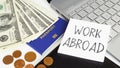 Working abroad is shown using the text and photo of passport and dollars Royalty Free Stock Photo