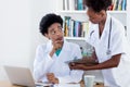 Working african american female doctor with young nurse or medical student Royalty Free Stock Photo