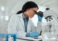 Working without any distractions. a young woman using a microscope in a scientific lab. Royalty Free Stock Photo