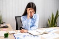 Working Asian women feel stressed, tired from work, migraine headaches from hard work while working at the office