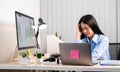 Working Asian women feel stressed, tired from work, migraine headaches from hard work while working at the office