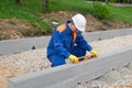 Working in a blue uniform, checks the level, the correct installation of curbs Royalty Free Stock Photo