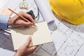 Working on blueprints. Construction project with hands writing o Royalty Free Stock Photo