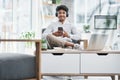 Working in a casual environment feels good. Portrait of a young businessman using a cellphone while working in an office Royalty Free Stock Photo