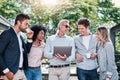 Working with a change of scene to generate fresh ideas. a group of businesspeople working together on a laptop outdoors. Royalty Free Stock Photo