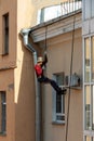 Working climber on the rope restores the facade of the house. air conditioner installation and repair Royalty Free Stock Photo