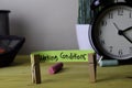 Working Conditions. Handwriting on sticky notes in clothes pegs on wooden office desk