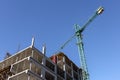 A working crane against a blue sky. Crane above the construction site. Industrial background Royalty Free Stock Photo