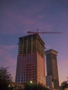 New Orleans, USA. December 2019. Working crane on a modern office building under construction during the sunset.