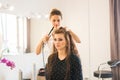 Working day inside the beauty salon. Hairdresser makes hair styling Royalty Free Stock Photo