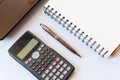 Working desk with calculator and laptop, pen, notebook on white Royalty Free Stock Photo