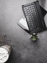 Working desk with coffee, glasses, cactus, notebook on concrete desk