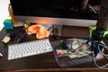 Working desk with computer and stuff.View over untidy workplace with modern computer, keyboard, earphones, leather