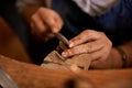 Working on the details. An artist creating something out of wood.