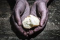 Working dirty hands of a man holding a crust of bread. Begging for a hand of hope. Give hope. The concept of alms and charity