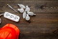 Working with electrical equipment. Hard hat, socket outlet, bulbs, screwdriver on dark wooden background top view copy Royalty Free Stock Photo