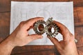 The working engineer holds a bevel gear in his hand against the background of a technical drawing Royalty Free Stock Photo