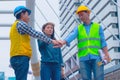 Working engineer.They are join hands mean teamwork and spirit beside building background. Royalty Free Stock Photo