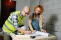 Working engineering team going over a blueprint, writing, making marks Royalty Free Stock Photo