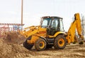 Working excavator tractor digging a trench at construction site Royalty Free Stock Photo