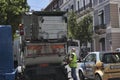 Working garbage trucks operate with garbage cans in the streets