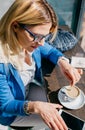 Working girl stiring coffee and looking phone Royalty Free Stock Photo