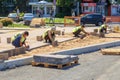 Working guest workers laying paving slabs in the city on the streets of the Young Guard in Sunny Summer Day