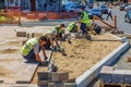 working guest workers laying paving slabs in the city on the streets of the Young Guard in Sunny Summer Day