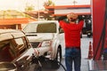 Working hard at a gas station with so many cars lined up that the male service personnel can`t keep up with stress. Royalty Free Stock Photo