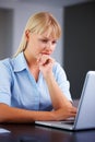 Working hard on project. Portrait of thoughtful young business woman using laptop. Royalty Free Stock Photo