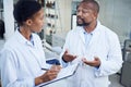 Working hard to crack the case. two scientists having a discussion in a lab.