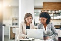 Working hard together to achieve big together. two businesswomen working together on a laptop in an office. Royalty Free Stock Photo